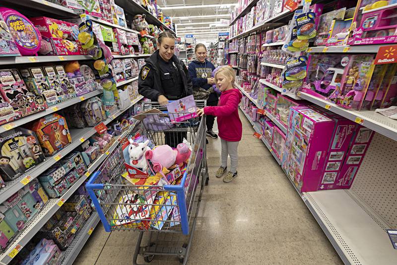 Faith Rosenbaum, 7, picks out a Barbie with Sterling officer Sierra Schmidt and mom Heather Millam Saturday, Dec. 9, 2023 during Sterling police’s Shop with a Cop. Through donations from the community, each child was allotted $150 to spend on gifts.