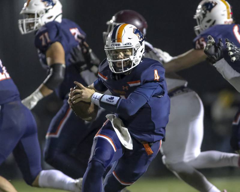 Oswego's Drew Kleinhans (4) scrambles away from pressure during Class 8A semifinal football game between Lockport at Oswego. Saturday, Nov 22, 2025 in Oswego.