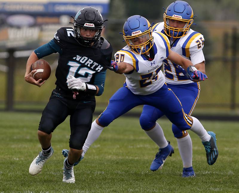 Woodstock North's Landan Creighton tries to get away from Johnsburg's Duke Mays during a Kishwaukee River Conference football game Saturday, Aug. 26, 2023, at Woodstock North High School.