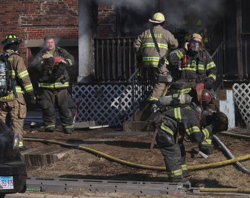 Firefighters exit the home during a fully engulfed house fire in the 800 block of Bucklin Street on Friday, Jan. 23, 2026 in La Salle.