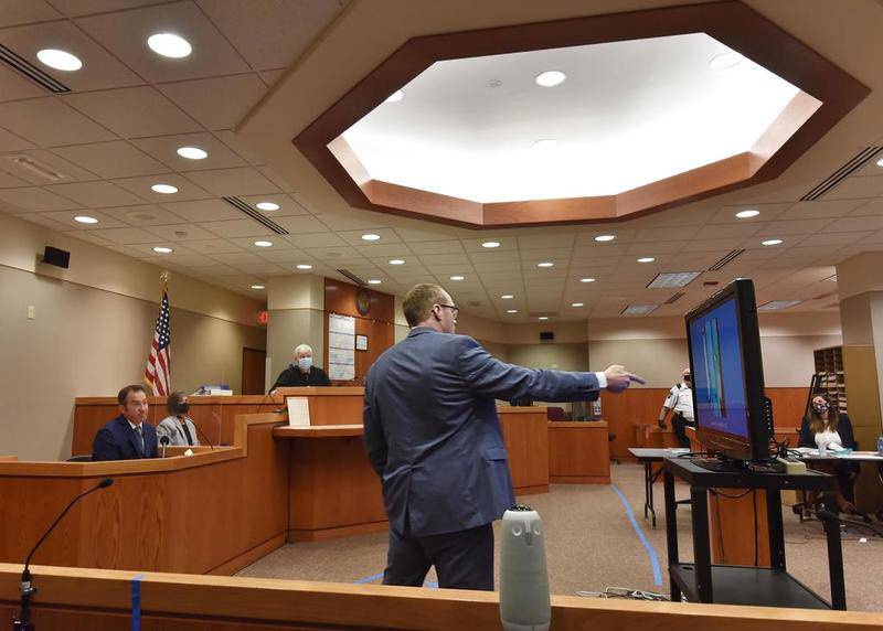 McHenry County State's Attorney Patrick Kenneally points to photographs on a flat screen as Crystal Lake Police Officer Brian Burr testifies in the JoAnn Cunningham sentencing hearing in Woodstock Thursday, July 16, 2020. The photos were of the Cunningham home on Dole Ave. in Crystal Lake. Cunningham pled guilty in December to killing her five-year-old son A.J. Freund Jr. in April, 2019 in her Crystal Lake home. His body was found in a shallow grave in Woodstock.