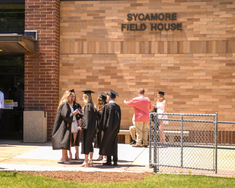 Sycamore graduates talk outside the fieldhouse before heading inside to line up for their commencement ceremony on Sunday, May 23, 2026, held at Sycamore High School.