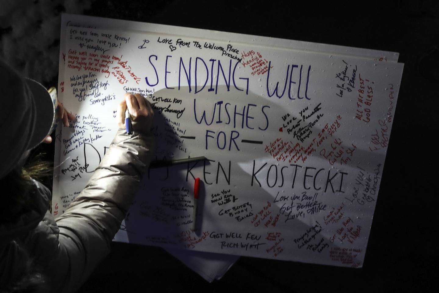 Vigil attendees sign a "get well" card for Deputy Ken Kostecki on Tuesday, Jan. 26, 2021, at Silver Cross Hospital in New Lennox, Ill. Family, friends and coworkers attended a candlelight vigil for Deputy Ken Kostecki of the Will County Sheriffs office who is currently on a ventilator as he battles COVID-19.