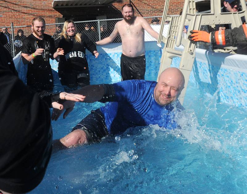 Chris Francisco, of Coal City, dips himself into the cold, shallow water for the Penguin Plunge as fellow Team Francisco members Doyle Jones (from left), of Rockford, Valerie Gordan, of Marseilles, and Josh Thumm, of Ottawa, watch Feb. 29, 2020 at the Knights of Columbus in Ottawa. This year, the Penguin Plunge will continue as a virtual event with future events being held at SkyDive Chicago.