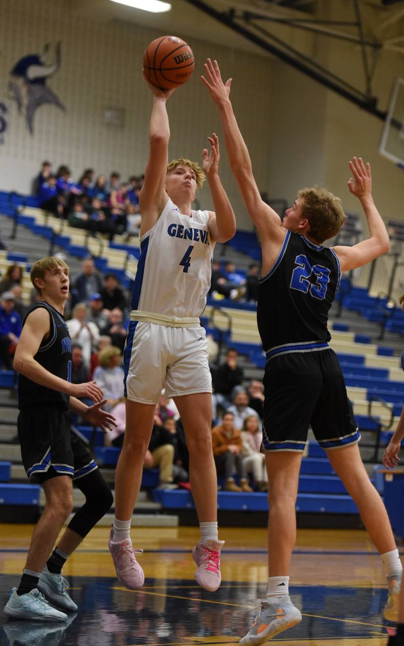 Joe Lewnard/jlewnard@dailyherald.com
Geneva’s Tanner Dixon, left, shoots as St. Charles North’s Luke Holtz gets a hand up on defense during Saturday’s game in Geneva.