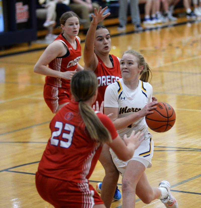 Polo's Camrynn Jones (4) drives to the basket against Oregon's Aniyah Sarvers (23) and Sarah Eckardt (13) during Tuesday, Dec. 5, 2023 action at Polo High School.