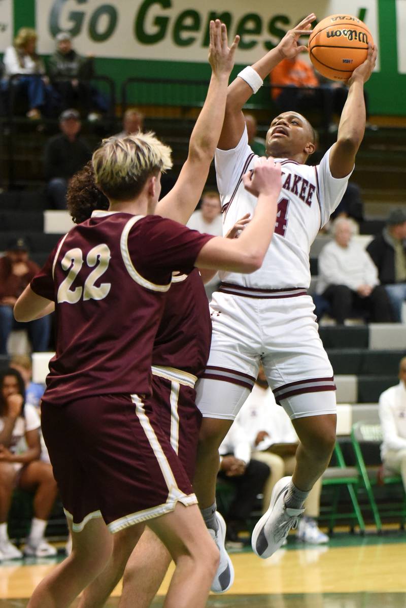 Kankakee's Myair Thompson, right, shoots as he's defended by a pair of Morris players during the IHSA Class 3A Geneseo Regional semifinals Thursday, Feb. 26, 2026.