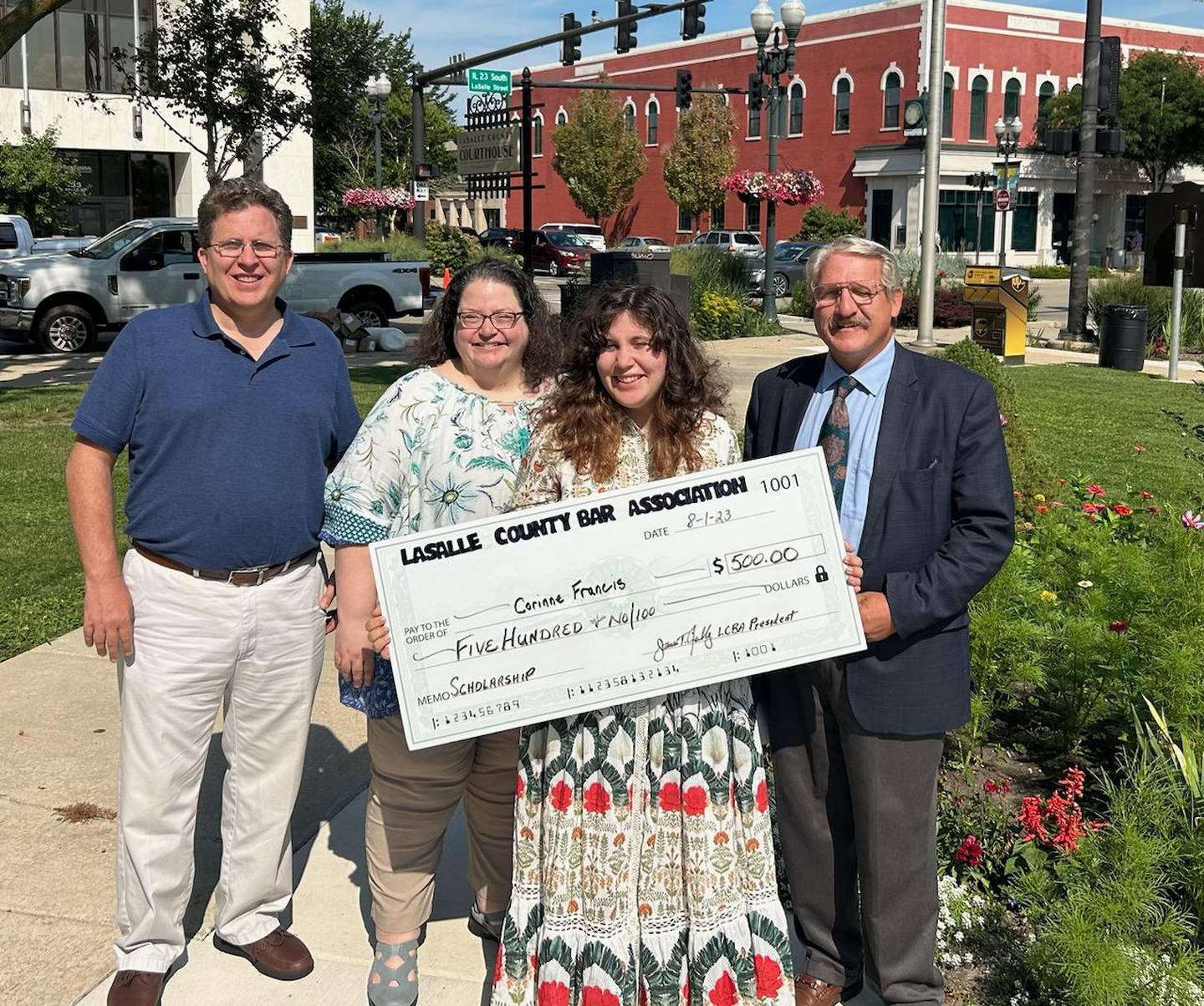 Corinne Francis (second from right), accompanied by parents Kevin and Heather, receives a $500 scholarship dated Aug. 1, 2023, from the La Salle County Bar Association at La Salle County's downtown courthouse. At the far right is La Salle County Bar President Jim Reilly.