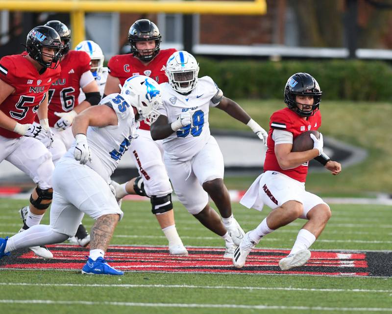 Northern Illinois Huskies quarterback Ethan Hampton, right, runs the ball to gain some yards before sliding during the game on Saturday Sept. 21, 2024, while taking on Buffalo.