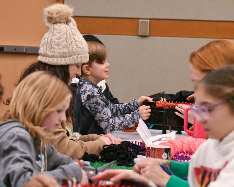 Will Pacini, 7, of Lombard knits a scarf with some help with a manual crank machine on Monday Jan 20. 2025, held at the Elmhurst library on Martin Luther King. Jr. Day of Service.