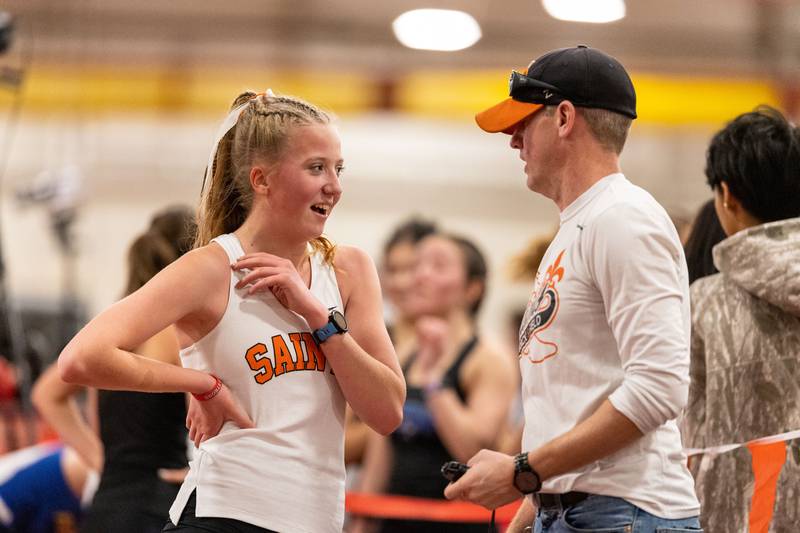 St. Charles East Coach Bradley Kaplan speaks to  runner Adley Wilson after she participated in the 3200 meter run during the Girls Track and Field DuKane Conference Meet at Batavia High School on Saturday, March 22, 2025.