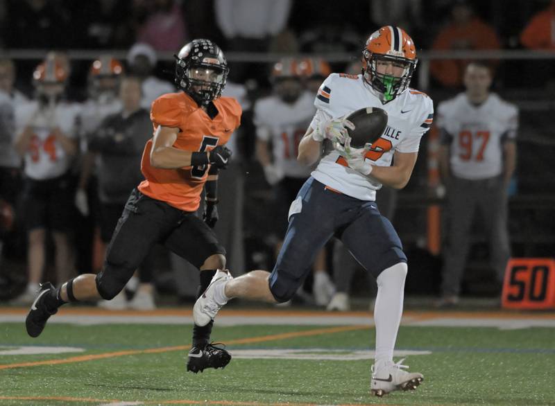 Naperville North’s Jack Zitko catches a long touchdown pass as Libertyville’s Ryan Faiz chases him late in the second quarter in a football game in Libertyville on Friday, Sept. 5, 2025.