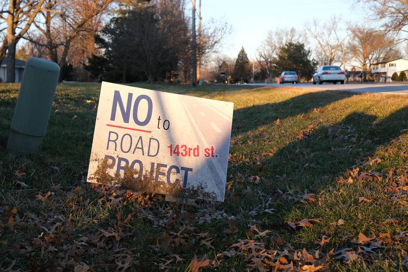 A resident displays a sign opposing the 143rd street extension project. Plainfield received federal grant money to extend 143rd Street east to Illinois Route 126. Thursday, Dec. 16, 2021 in Plainfield.