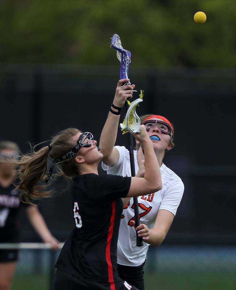 Huntley's Leah Holmberg battles with Crystal Lake Central co-op's Anna Starr for the ball during a Fox Valley Conference girls lacrosse match on Friday, April 17, 2026, at Crystal Lake Central High School.