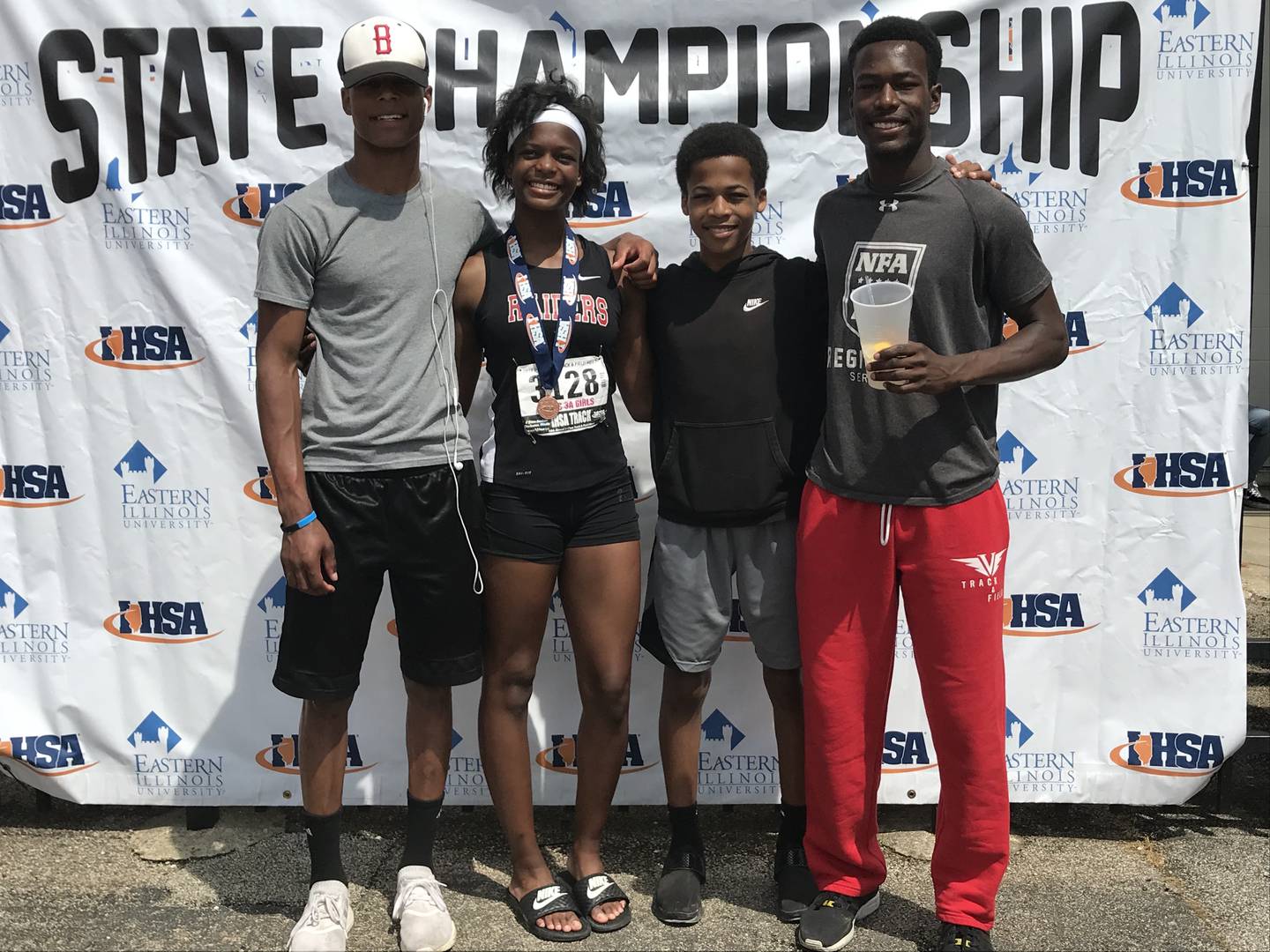 Justin, Kayla, Damon and Brendon pose after Kayla's race at the IHSA girls track and field state championships.