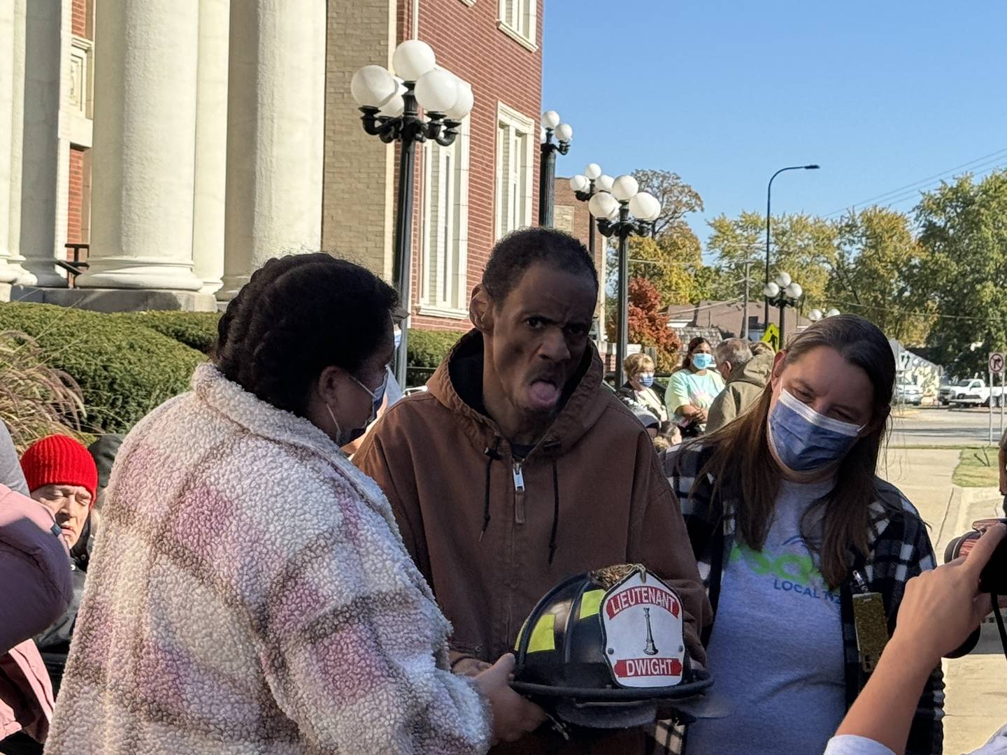 Kevin (center) gets to try on one of the firemen's helmets.