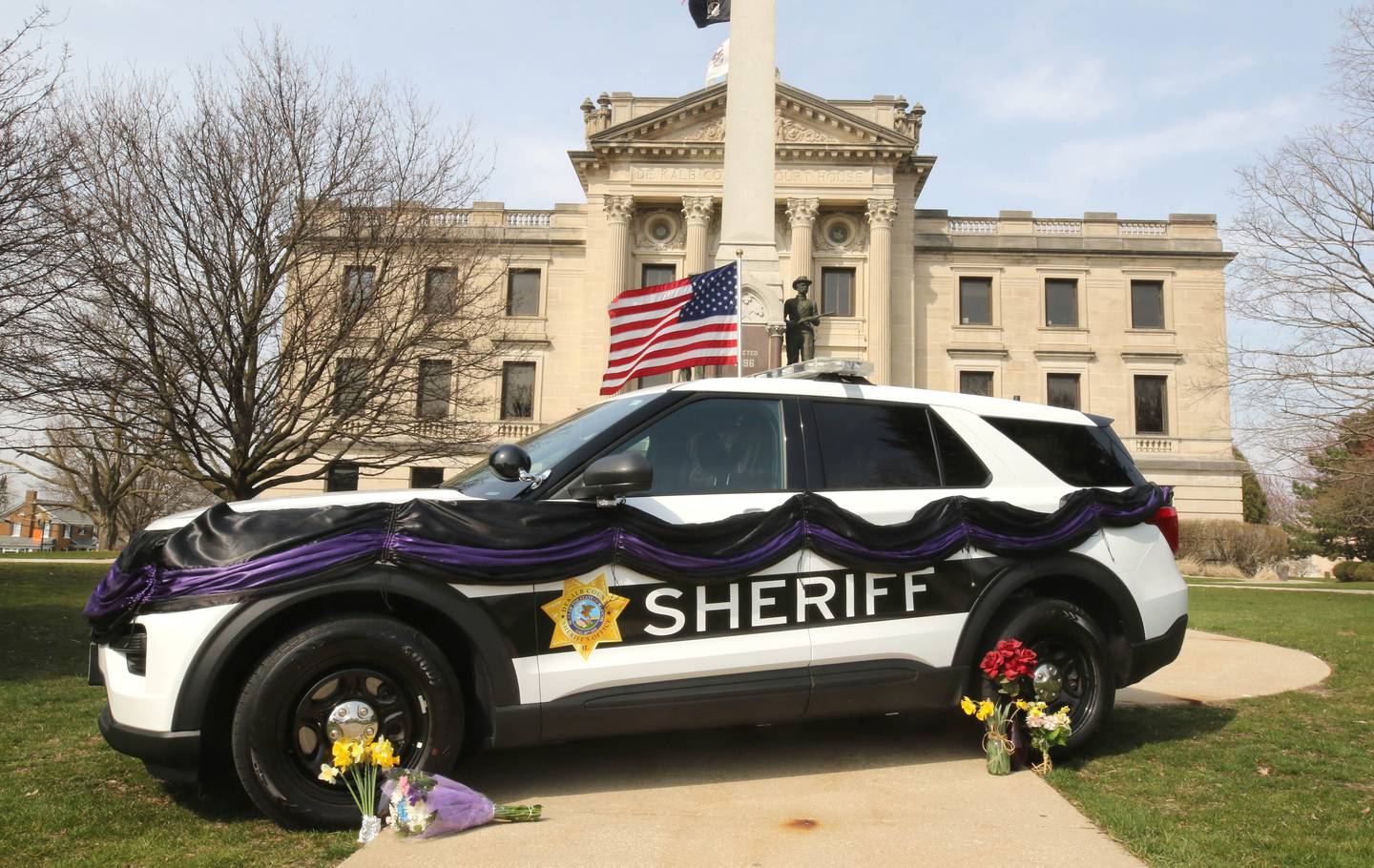 A DeKalb County Sheriff’s vehicle with black and purple bunting sits in front of the DeKalb County Courthouse in Sycamore Friday, March 29, 2024, as a memorial to DeKalb County Sheriff’s Deputy Christina Musil, 35, who died in a crash while working a shift Thursday night.