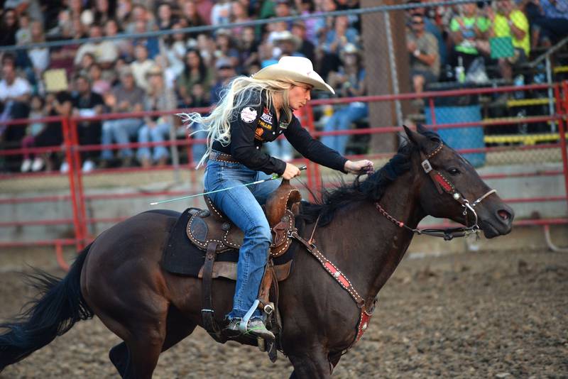 Kinley Northrup races her horse to the finish line in one of the barrel racing divisions at the T & A Bucking Bulls Rodeo during the Ogle County Fair on Friday, Aug. 1, 2025 in Oregon.