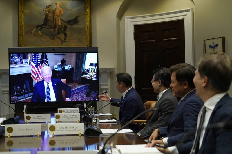 President Joe Biden, on screen at left, listens as SK Group Chairman Chey Tae-won, center, speaks from the Roosevelt Room of the White House in Washington, Tuesday, July 26, 2022. The meeting comes as the Biden administration is seeking the cooperation of Asian allies such as South Korea to reinforce supply chains for critical components such as semiconductors. (AP Photo/Susan Walsh)