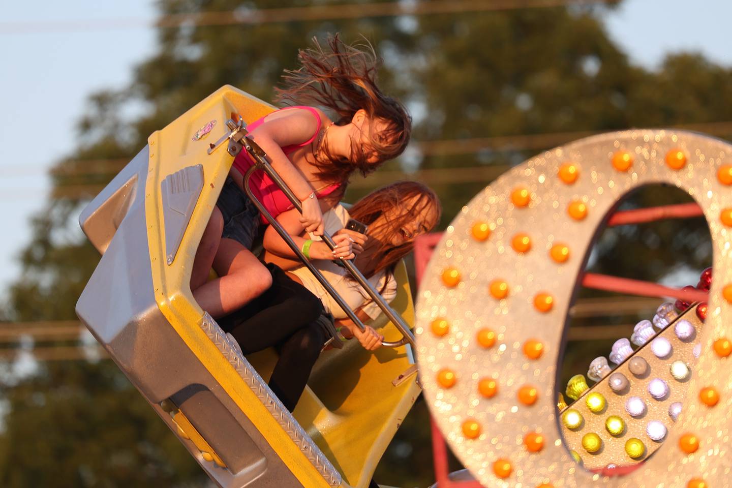 Hair flies in the faces of a couple riders on the Orbiter at Lockport’s Canal Days on Friday, June 9, 2023.