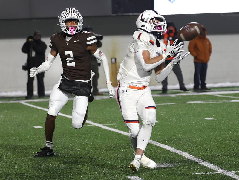 Oswego's Teddy Manikas makes a catch in front of Mount Carmel's Tavares Harrington Wednesday, Dec. 3, 2025, during their IHSA Class 8A state chamionship game in Huskie Stadium at Northern Illinois University in DeKalb.