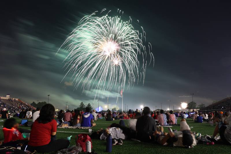 People watch the firework display from the field at Joliet Memorial Stadium in on Thursday July 4, 2024.