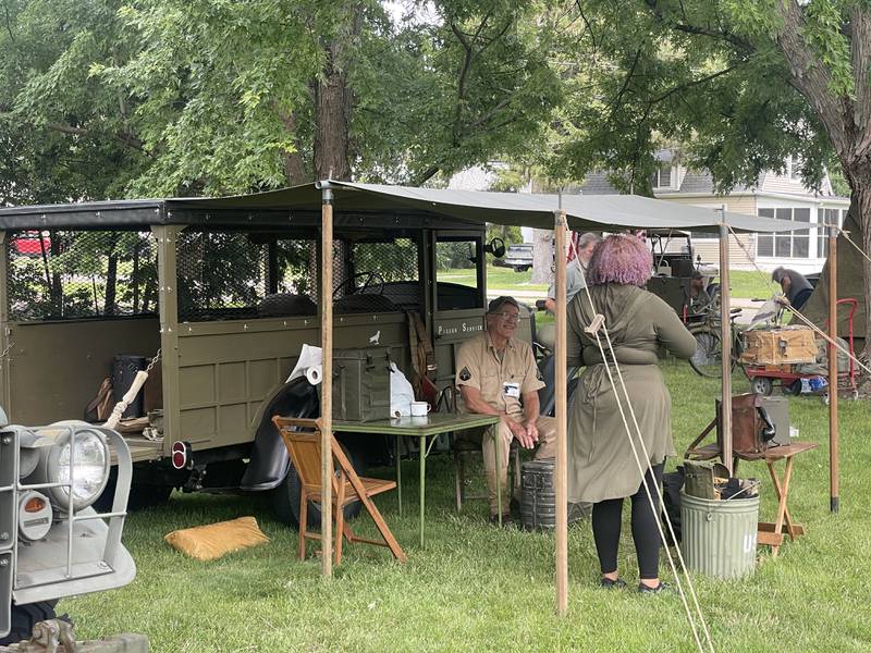 Larry Skinder (left) greets an attendee Saturday, Aug. 2, 2025, during Veterans Weekend in Genoa. He used the event to showcase the pigeon loft that he built from scratch.