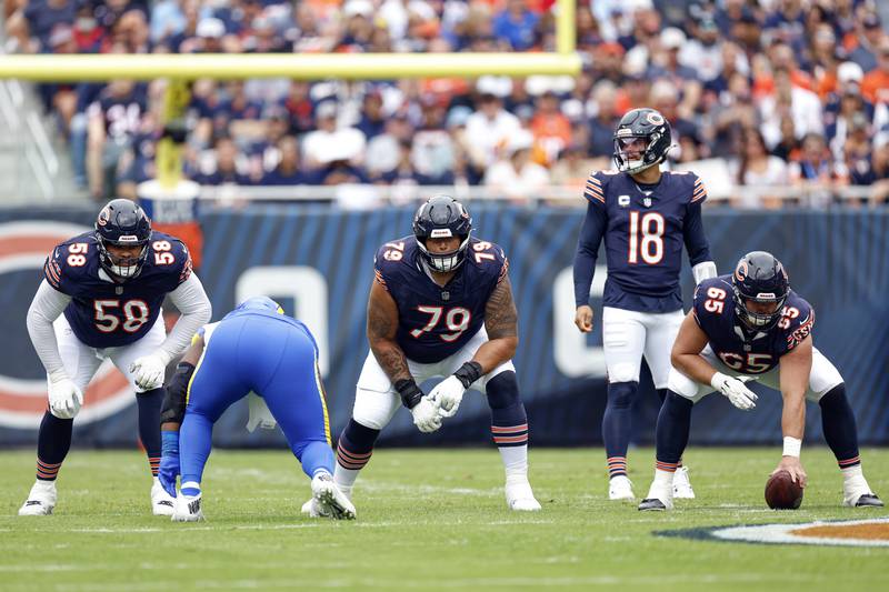 Chicago Bears center Coleman Shelton (65) waits to snap the ball to quarterback Caleb Williams (18) as offensive tackle Darnell Wright (58) and guard Matt Pryor (79) line up during the first half of an NFL football game against the Los Angeles Rams, Sunday, Sept. 29, 2024, in Chicago. The Bears defeated the Rams 24-18. (AP Photo/Kamil Krzaczynski)