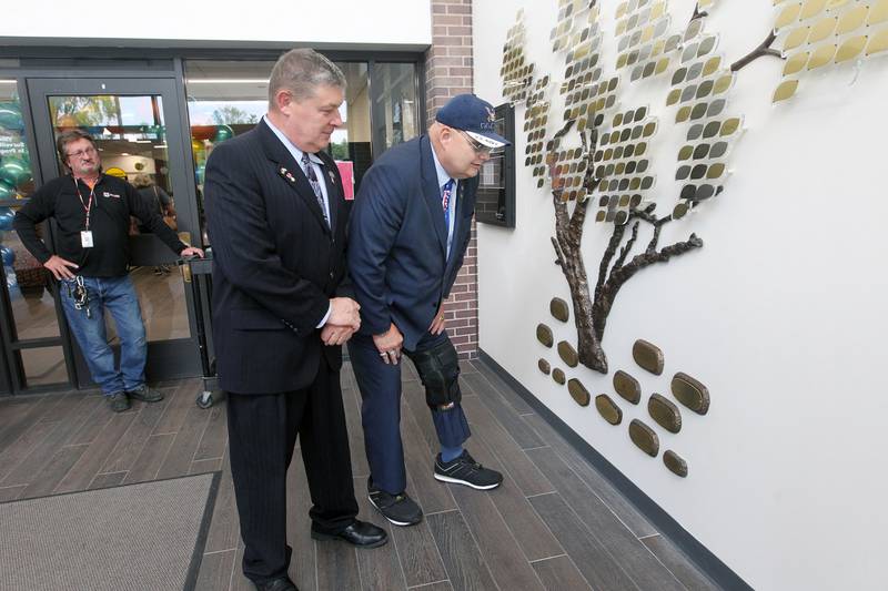 Roy Olnhausen, of Salem, Wis., maintenance manager, watches Paul Hettich, library board president, stand with Donald Fencl, of Antioch, a U.S. Navy veteran, as they look at a plaque Saturday, May 13, 2023, on the Giving Tree with Fencl's name of it to honor him for his donations to the library given to him during the Antioch Public Library District Open House in Antioch.