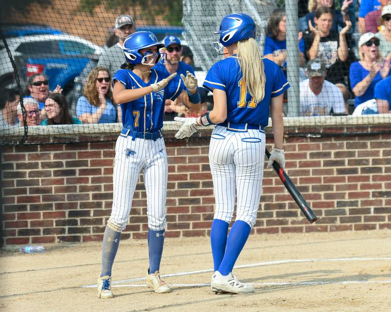 Wheaton North's Hana Stoner (7) gets congratulated by teammate Makayla Hammer (11) after Hana scores a run during the sectional semifinal game on Thursday June 5, 2025, while taking on Weaton Warrenville South held at Oswego High School.