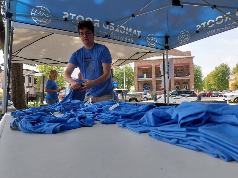 Ryan Nolasco of the Ottawa Visitors Center folds Drinkin' with Lincoln T-shirts Saturday, July 27, 2024, during the inaugural event at Washington Square in Ottawa.