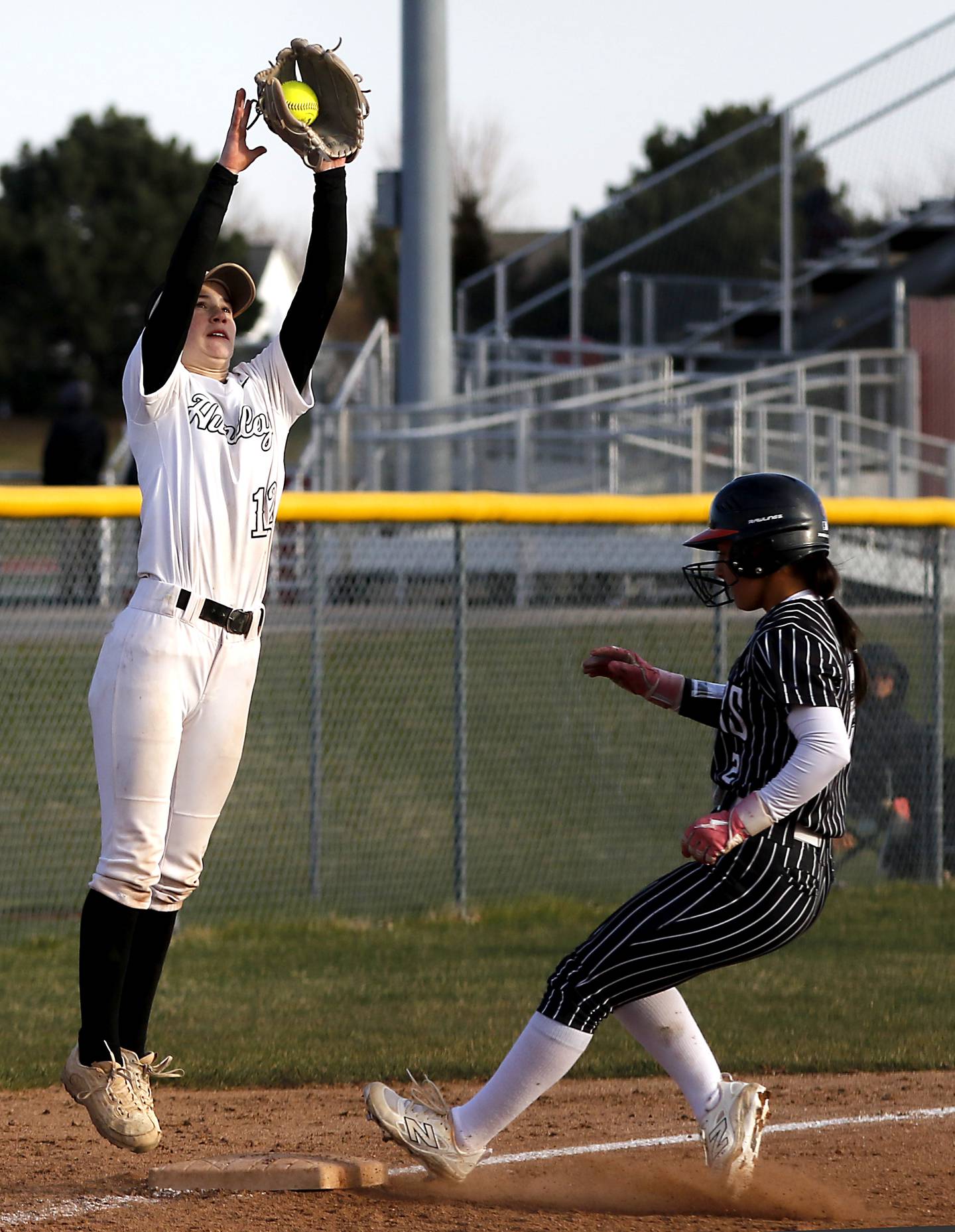 Huntley's Aubrina Adamik jumps to catch the throw to third base as Crystal Lake Central's Ella Arana safely takes there base during Fox Valley Conference softball game on Tuesday, April 8, 2025, at Huntley High School.