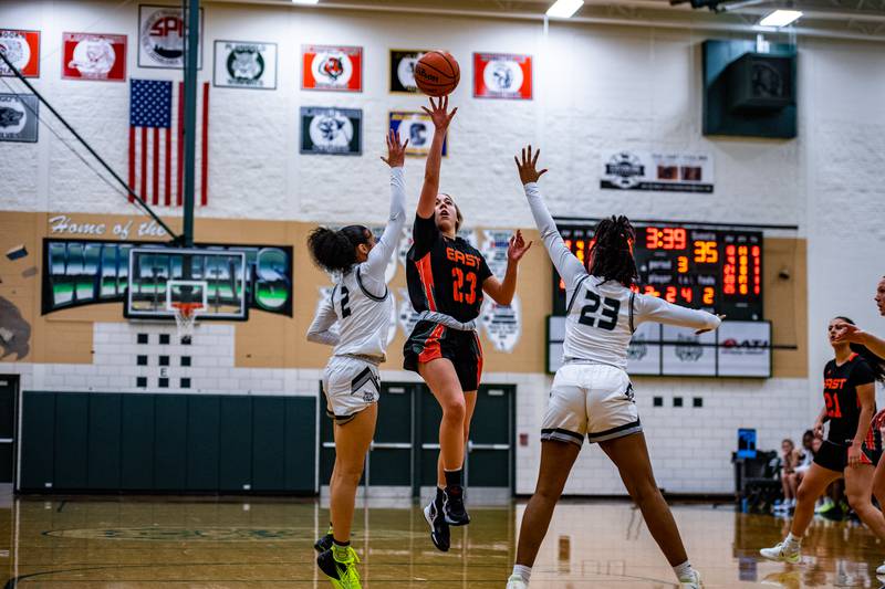Plainfield Easts Lexi Sepulveda lays up a shot as Plainfield Centrals Aaliyah Frazier and Ciara Dotson defend during a game  Thursday Dec. 1, 2022 at Plainfield Central  High School