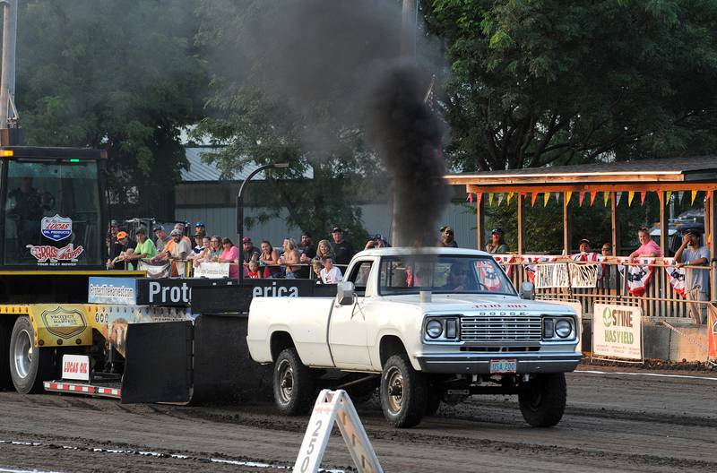 Cody Jones of Marseilles' 1977 Dodge Truck, billows black smoke as he pulls the drag during the Tractor Pull competition at the Kendall County Fair in Yorkville on Friday, Aug. 2, 2024.
