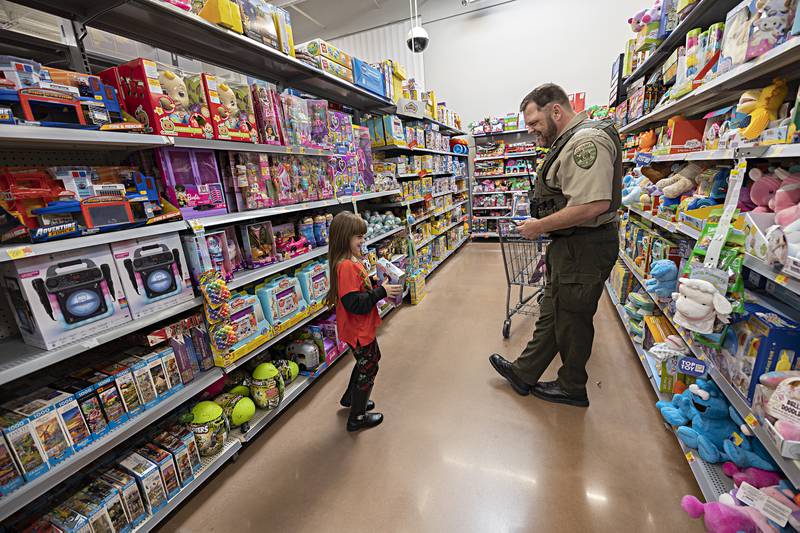 Emalyn Ellis, 7, excitedly shows Lee County Deputy Ryan Pettenger a gift Saturday, Dec. 9, 2023 during Shop with a Cop. Dixon, Lee County and Polo all participated in Saturday’s shopping spree.