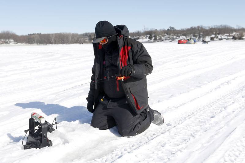 Trevor Janes, who owns Wet N Wild Outfitters, ice fishes Friday, Feb 3. 2023, on Petite Lake near Fox Lake.