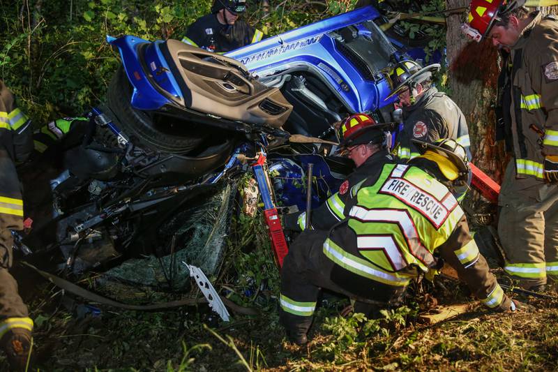 Fire departments from Nunda, McHenry Township and Cary assist in getting the driver out of the rolled over vehicle on Gracy Road, June 22, 2023.