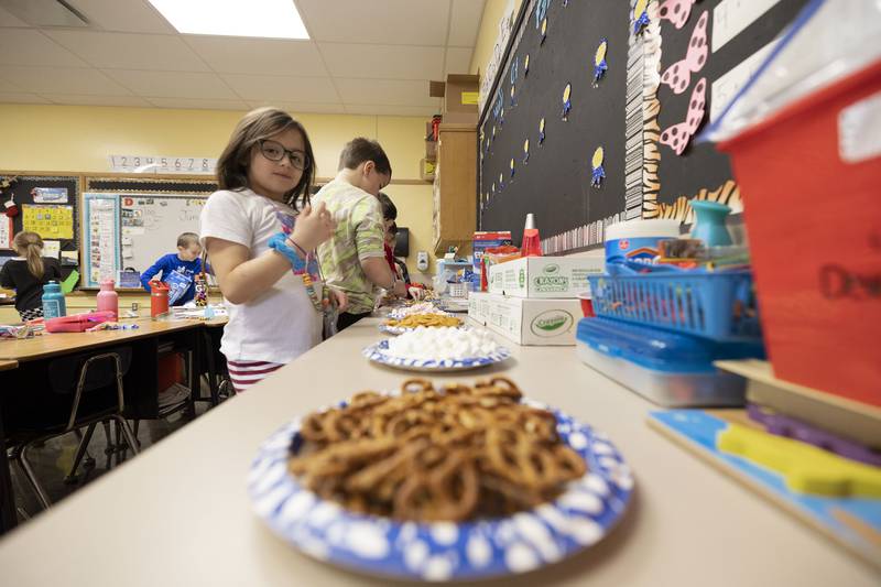 First grader Alaya Chacon makes her way down the line, counting snack for the 100 days exercise. Some of the treats teacher Mandy Dallas dished out were M&M’s, marshmallows, pretzels and chocolate chips.