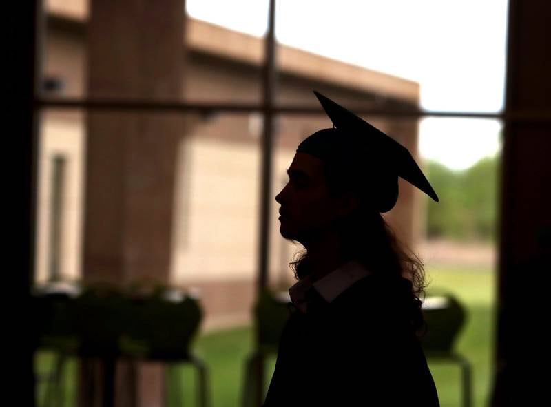 Cameron Jordan is silhouetted as he waits with others to march for graduation at Woodstock North High School in Woodstock on Saturday, May 17, 2025.