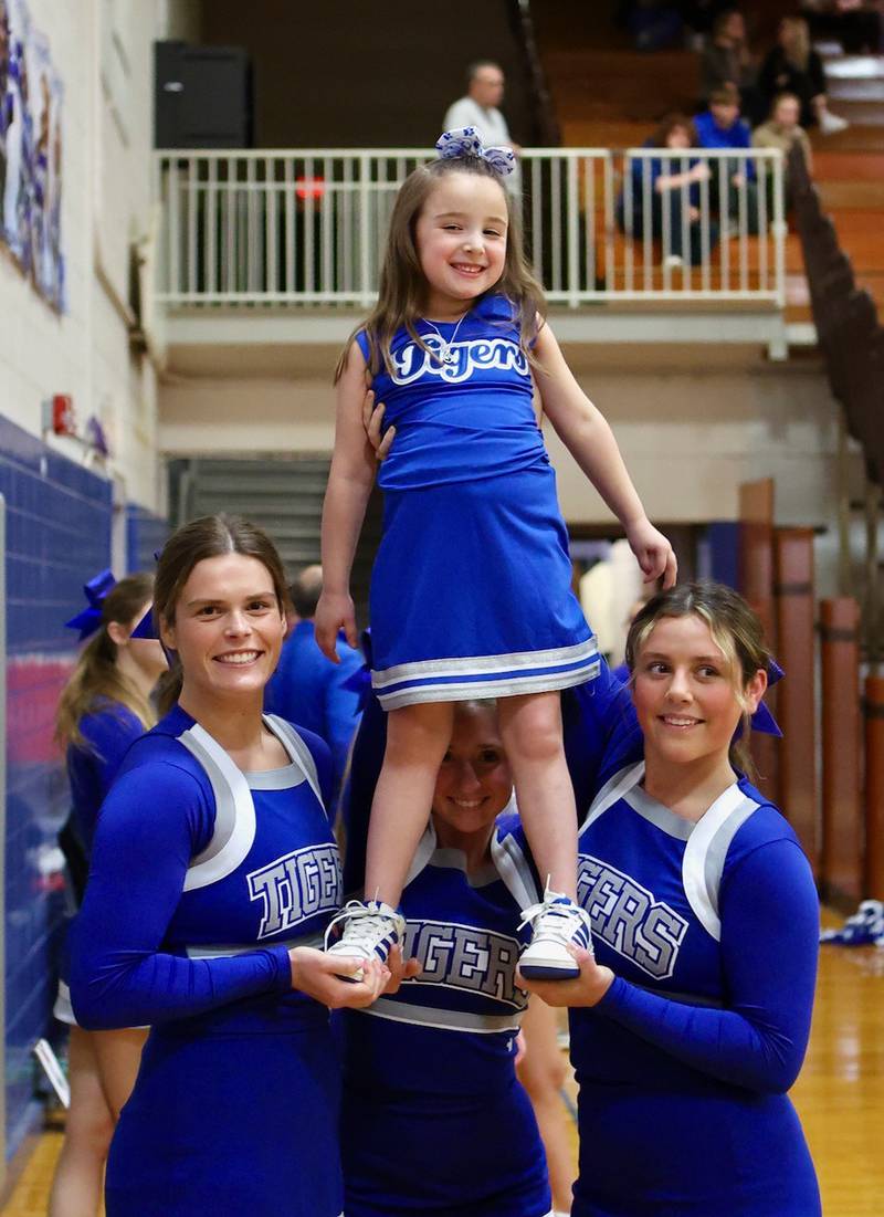 Monroe Michlig, 4, gets a boost from Princeton High School cheerleaders Ella Harp (left), Paige Jesse and Sylvie Rutledge Saturday night at Prouty Gym. Monroe followed the big girls every cheer.