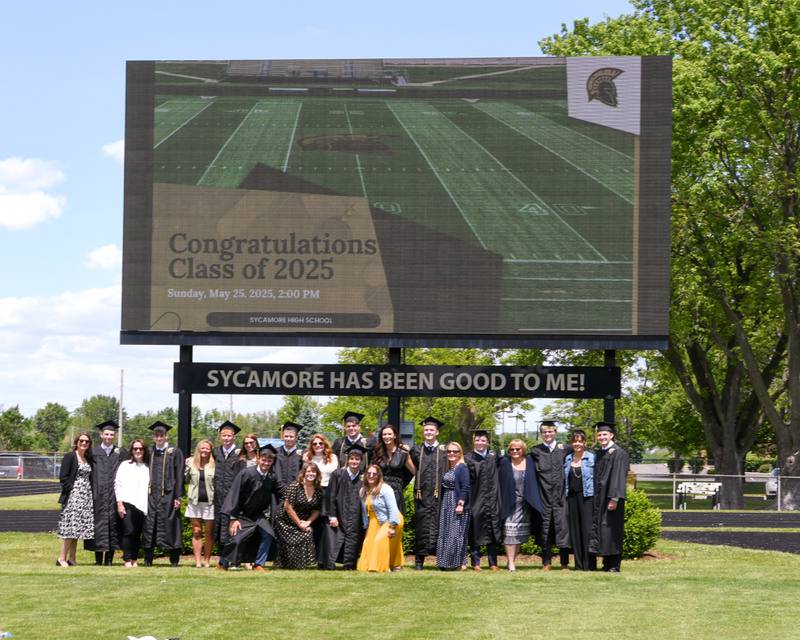 Sycamore High School graduating seniors and members of the football team pose for a photo with their mothers in front of the scoreboard on Sunday, May 25, 2025, before the Class of 2025 Commencement ceremony at the high school.