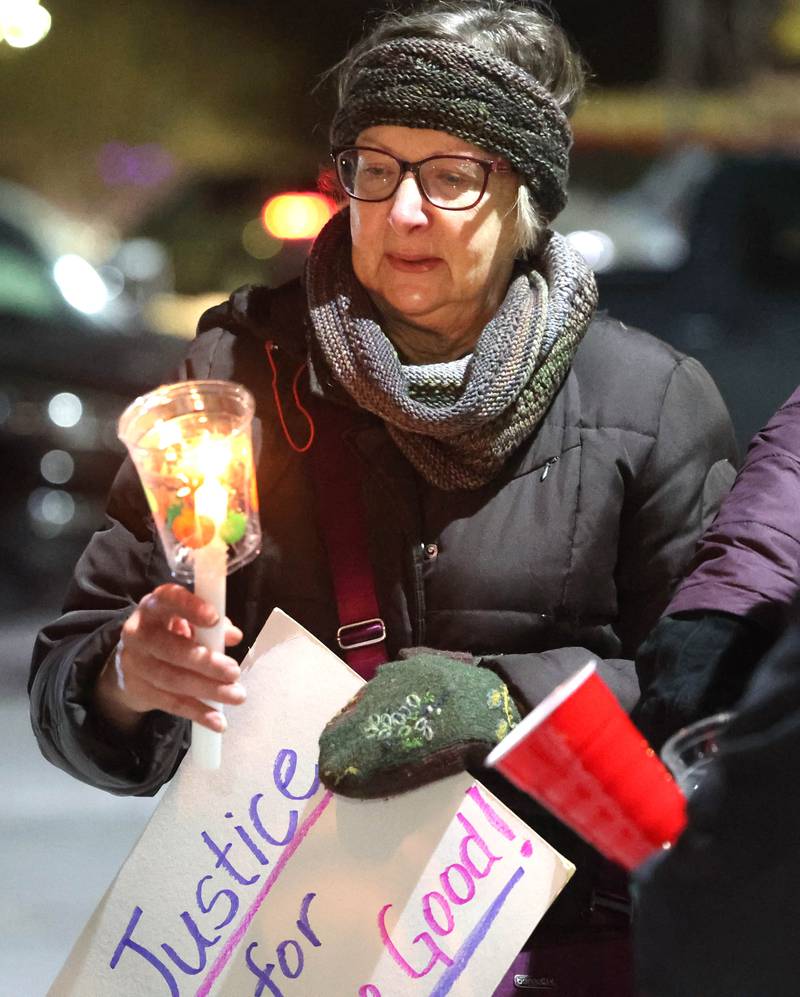 Jane School holds a candle Monday, Jan. 26, 2026, during a vigil outside the DeKalb County Legislative Center in Sycamore after second shooting death in Minnesota involving ICE officers.