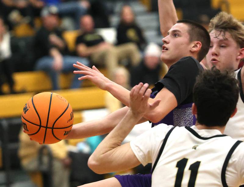Dixon’s Cullen Shaner goes to the basket between Sycamore's Jake Shipley and Isaiah Feuerbach during their game Tuesday, Jan. 14, 2025, at Sycamore High School.