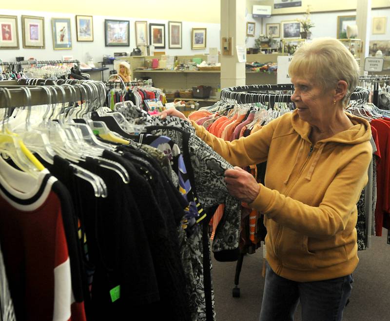 Volunteer Linda Avolio hangs clothing on a rack as she works at the Sparrow's Nest Thrift Store and Donation Center, 3714 W. Elm St. in McHenry on Thursday, March 31, 2022. Sparrow's Nest is looking grow its volunteer base.