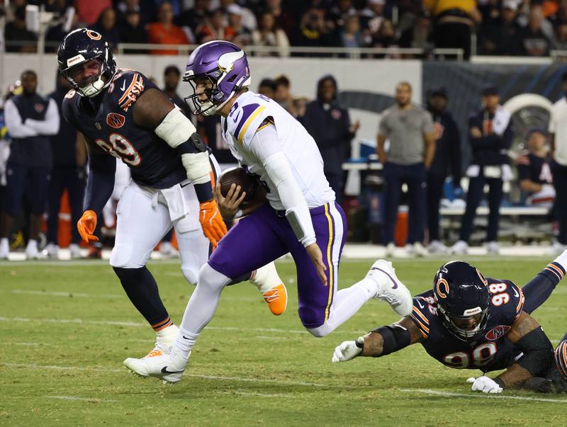 Minnesota Vikings quarterback, and LaGrange Park native, J.J. McCarthy escapes from Chicago Bears defensive end Montez Sweat and defensive tackle Gervon Dexter Sr. during their game Monday, Sept. 8, 2025, at Soldier Field in Chicago.