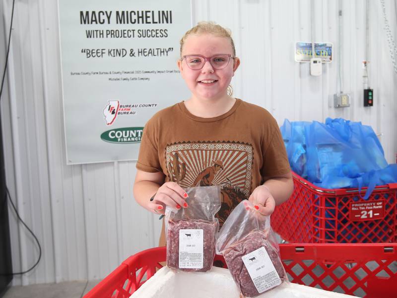 Macy Michelini,10, of Peru, poses with some frozen beef on Wednesday, June 25, 2025, at the Hall Township Food Pantry in Spring Valley. Michelini donated a full cow with 400 pounds of beef to the food pantry through her"Beef Kind and Healthy" distribution.