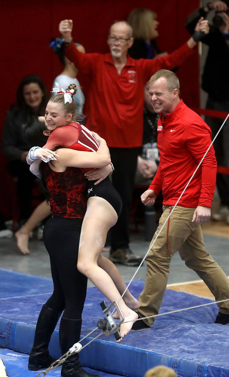 Patatine’s Jolee Weddington receives a hug after competing in the preliminary round of the parallel bars on Friday, Feb. 20, 2026, during the IHSA Girls State Final Gymnastics Meet at Palatine High School.