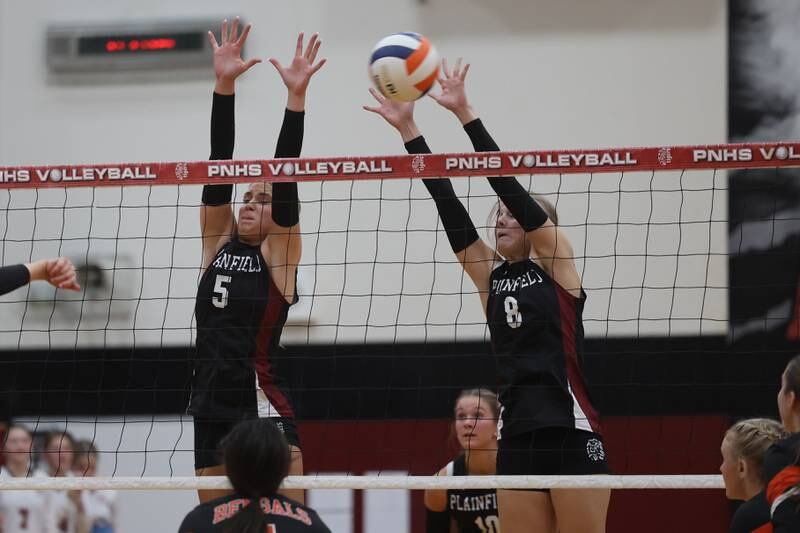 Plainfield North’s Lizzie Fitzgerald, left, and Sydney Pavlik go for the block against Plainfield East on Tuesday, Oct. 10, 2023 in Plainfield.