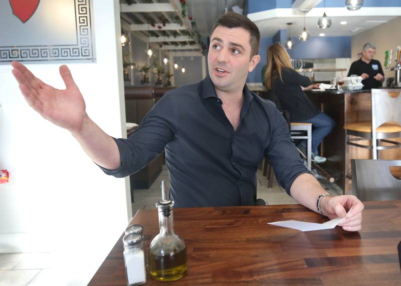 The Flame traditional Greek grill owner Foti Pappas points out some of the decor Friday, Jan. 19, 2024, in the new eatery at 209 East Lincoln Highway in DeKalb.