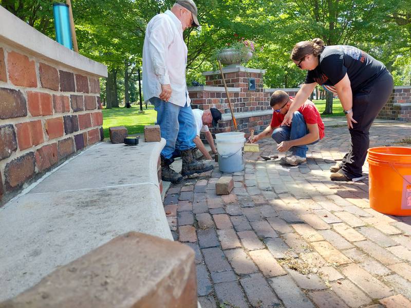 Volunteers from Laborers Local 393 out of Marseilles work on sprucing up the Reuben Soderstrom Plaza in Streator. (From left) David Raikes, David Pierce, Mike Matuszewski and Sarah Lagow work on a specific section of the plaza.